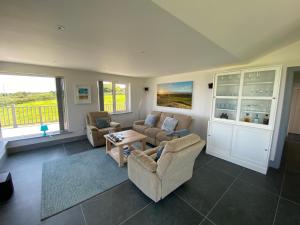 a living room with two couches and a table at House Gowlane in Castlegregory +19 photos