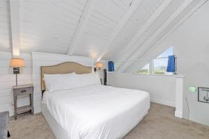 sypialnia z białym łóżkiem i oknem w obiekcie Tidal House 9 w mieście Ocean Shores