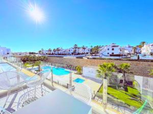 a balcony with white chairs and a swimming pool at Soleil Villamartin Golf in Villamartin