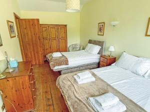 1 Schlafzimmer mit 2 Betten und Holzboden in der Unterkunft Angel Cottage in Oswaldkirk