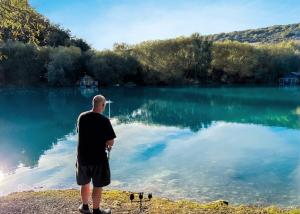 Un uomo in piedi di fronte a un lago di St Andrews Lakes 