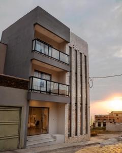 a tall building with a sunset in the background at Pousada Canto da Montanha in São Thomé das Letras