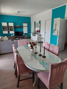 ein Esszimmer mit einem Tisch und rosa Stühlen in der Unterkunft Villa Roza 1 in Marina