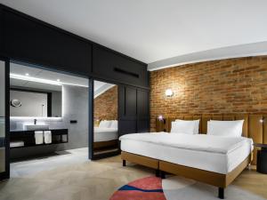 1 dormitorio con cama y pared de ladrillo en Mercure Krakow Fabryczna City en Cracovia