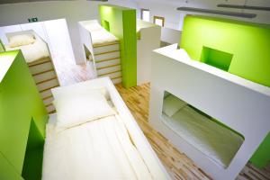 Cette chambre comprend 2 lits verts et blancs. dans l'établissement Youth Hostel Ajdovscina, à Ajdovščina