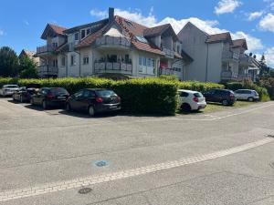 a large house with cars parked in a parking lot at Design-Terrasse-7 Personen-Netflix-Garage-Seenah in Radolfzell am Bodensee