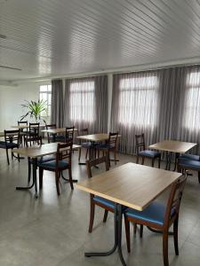 a dining room with tables and chairs and windows at HOTEL PORTO in Valença