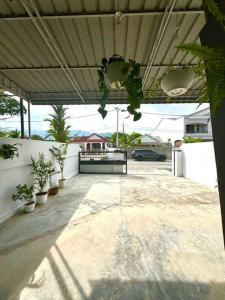 eine leere Terrasse mit Topfpflanzen und einem Dach in der Unterkunft Homey Feel Pearl Cottage in George Town