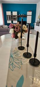 einen Tisch mit drei Kerzen und eine Vase Blumen in der Unterkunft Villa Roza 1 in Marina