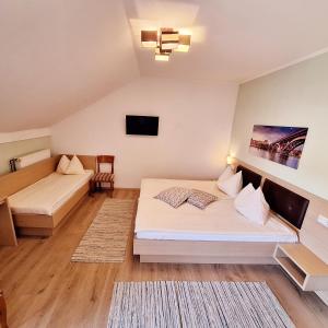 ein Hotelzimmer mit 2 Betten und einem TV in der Unterkunft Penzion Gostisce Lesjak in Orehova vas 