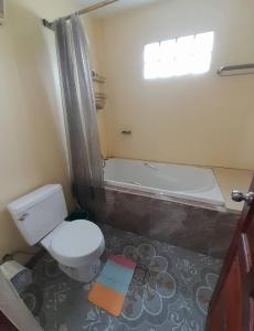 a bathroom with a toilet and a bath tub at พลอยฟ้ารีสอร์ทเขาเต่า Ployfarresortkhaotao in Khao Tao