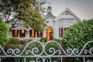 a white house with a gate in front of it at Bonne Esperance Boutique Guest House in Stellenbosch