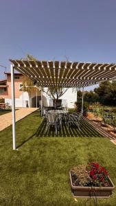 a patio with a table and chairs under a pergola at Angel House in Drosia