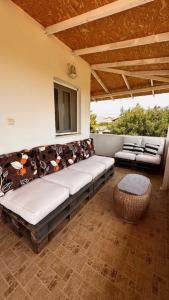 a porch with a couch and a table and chairs at Angel House in Drosia