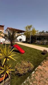 a backyard with a red slide on the grass at Angel House in Drosia