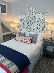 um quarto com uma grande cama branca com almofadas em Rooms at number one em Broadstairs