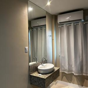 y baño con lavabo y espejo. en Onix Hotel Aeroporto en Lauro de Freitas