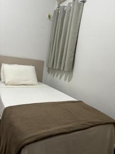 a bedroom with a bed with a pillow and curtains at HOTEL PORTO in Valença