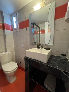 a bathroom with a sink and a toilet and a mirror at Mano’s House Preveza in Preveza