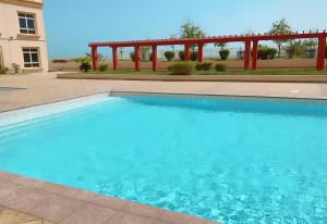 una piscina con acqua blu in un cortile di غرفتين مطله عوائل a King Abdullah Economic City