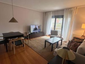 a living room with a couch and a piano at Camino Santiago Naturaleza en Logroño Parking y Piscina by Apartamentos Logrono org in Logroño