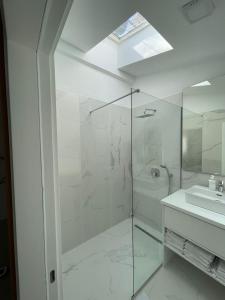 a bathroom with a glass shower and a sink at Lungomare Apartments in Petrovac na Moru