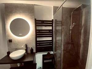 a bathroom with a sink and a shower with a mirror at Appartement 1000 et une nuits in Saint-Avold