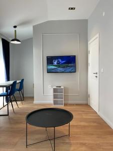 a living room with a table and a tv on the wall at Lungomare Apartments in Petrovac na Moru