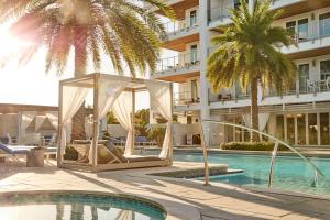 un hotel con piscina con cenador y palmeras en Texas Two Step en Rosemary Beach