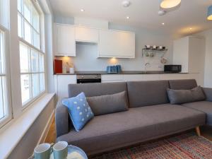a living room with a couch and a kitchen at The Seven Sands in Dymchurch