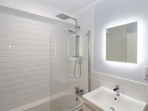 a white bathroom with a shower and a sink at The Seven Sands in Dymchurch +31 photos