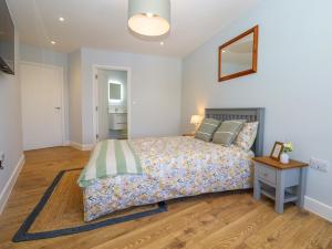 a bedroom with a bed and a table and a mirror at The Seven Sands in Dymchurch