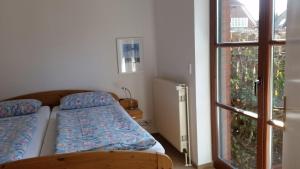 - une petite chambre avec un lit et une fenêtre dans l'établissement Nettes Appartement in Warwerort mit Garten, Terrasse und Grill, à Warwerort