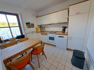 een keuken met een houten tafel en een tafel en stoelen bij Nettes Appartement in Warwerort mit Garten, Terrasse und Grill in Warwerort