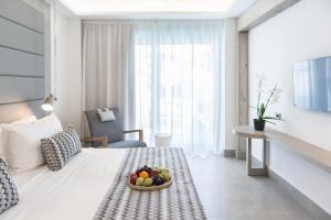 a hotel room with a bowl of fruit on a bed at Glaros Beach Hotel in Hersonissos