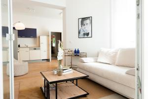a living room with a white couch and a table at Luxuswohnung im Herzen Potsdams! in Potsdam