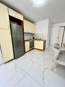 eine Küche mit weißen Marmorböden und einem Kühlschrank aus Edelstahl in der Unterkunft Blue Note Resort & Club in Athen