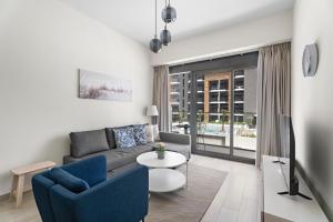 una sala de estar con un sofá y una mesa en Beautiful 1 BR with Gym, Pool & Kid's Playground, en Dubái 9 fotos más