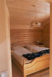 FalkertseeにあるFerienhaus für 4 Personen ca 70 qm in Falkertsee, Kärnten Oberkärntenの木製の壁のドミトリールームのベッド1台分です。