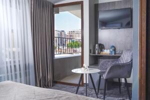 a room with a bed and a table and a window at Median Hotel, City Center Yerevan in Yerevan +48 photos