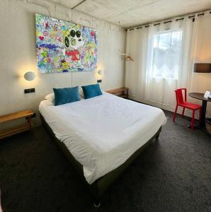 1 dormitorio con 1 cama grande y una pintura en la pared en Théo Hôtel Limoges, The Originals City, en Limoges