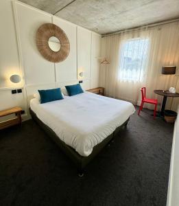 リモージュにあるThéo Hôtel Limoges, The Originals Cityのベッドルーム1室(大型ベッド1台、赤い椅子付)