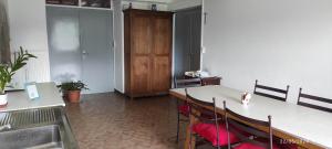 a kitchen with a table with chairs and a sink at Autrefois la Cure in Bonnefontaine