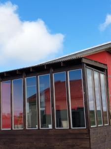 un edificio con ventanas de cristal y un edificio rojo en The red house near the sea, en Njarðvík