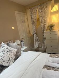 a bedroom with a bed and a dresser and a window at The POPULAR Chester Racecourse Apartments, Duplex, Sleeps 4, FREE Parking in Hough Green