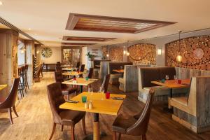 um restaurante com mesas e cadeiras de madeira em Fermain Valley Hotel em St Peter Port