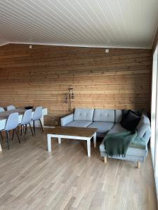 een woonkamer met een bank en een tafel en stoelen bij Voss Resort Bavallstunet in Skulestadmo