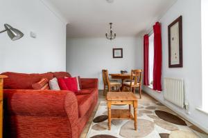 ein Wohnzimmer mit einem Sofa und einem Tisch in der Unterkunft GuestReady - Parkside getaway in Britannia Village in London