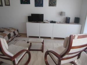 uma sala de estar com duas cadeiras e uma televisão em Ferienwohnung mit Hallenbad em Berg