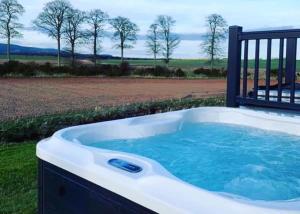 a jacuzzi tub with a view of a field at Royal Arch Park in Fettercairn